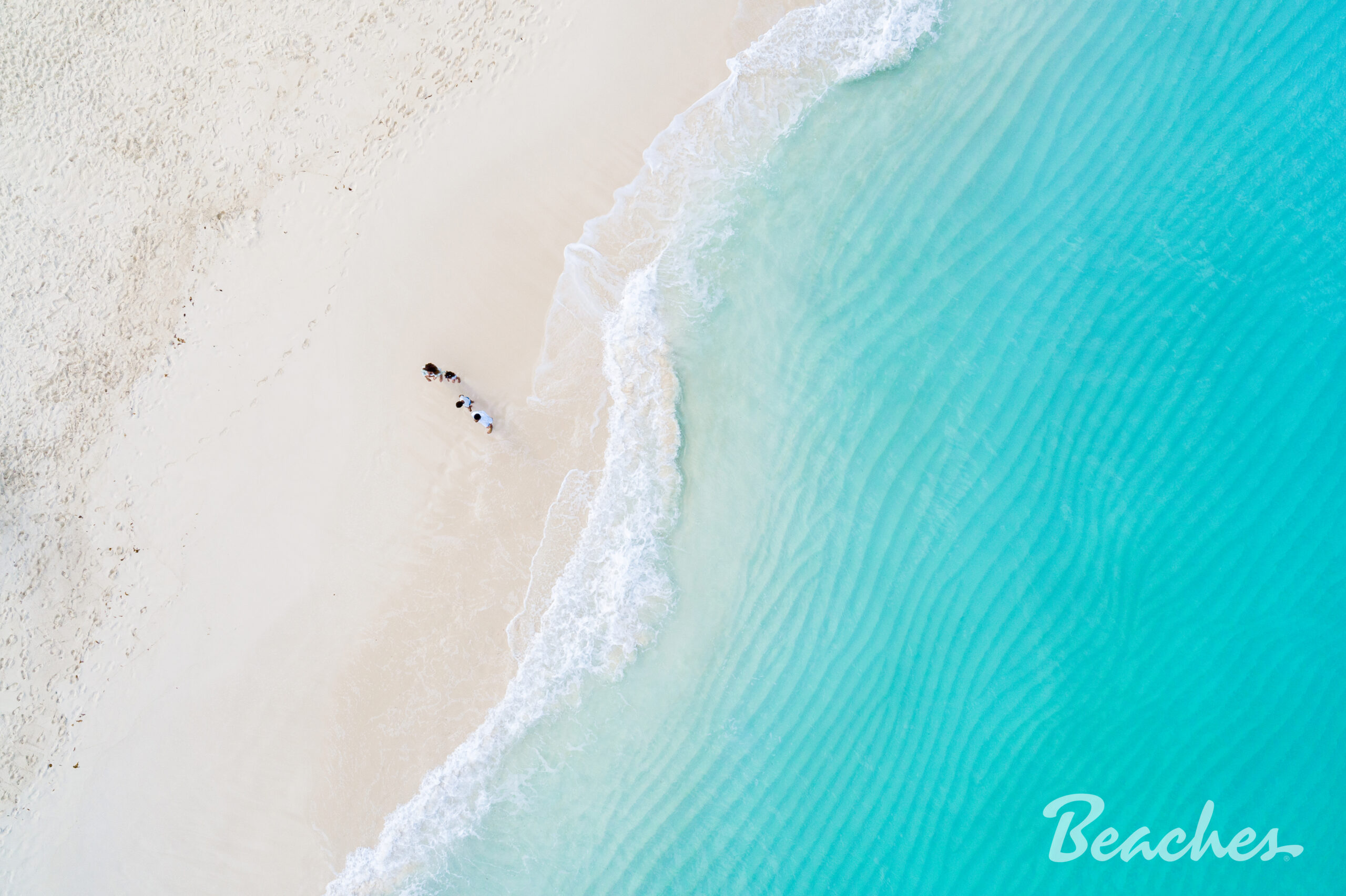 aerial shot of a beautiful beach with white sand and blue water